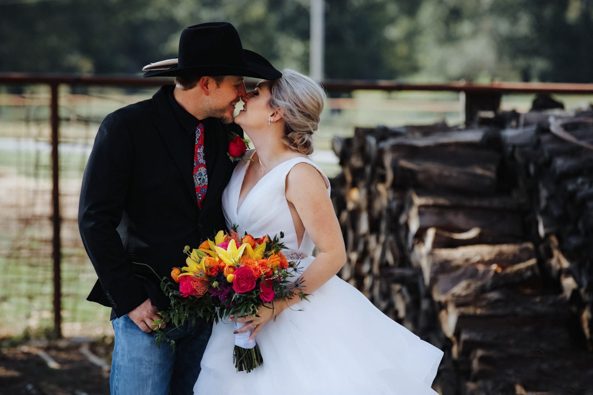 Newlyweds sharing a kiss at a rustic outdoor destination wedding
