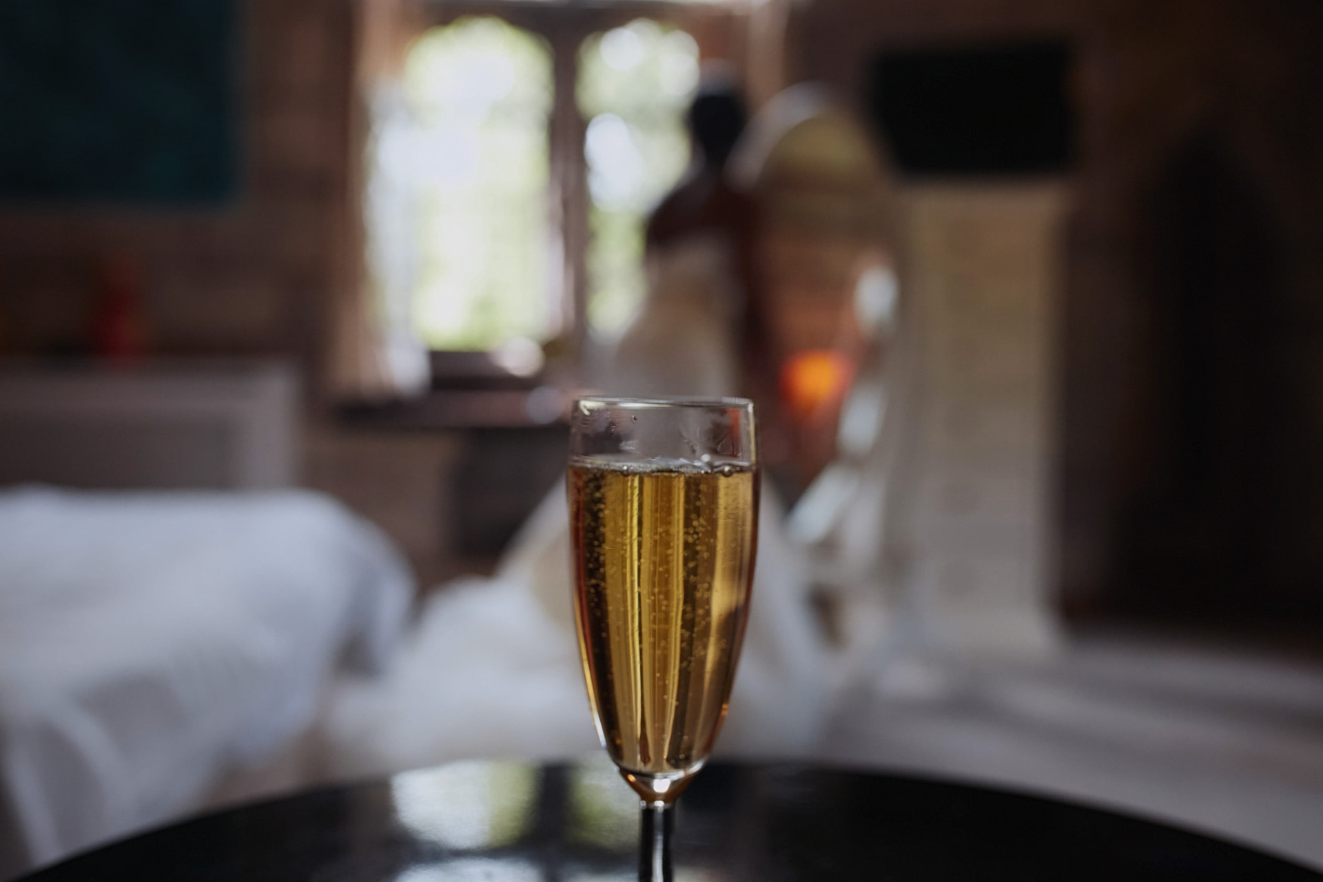 Glass of champagne with the bride getting ready in the background