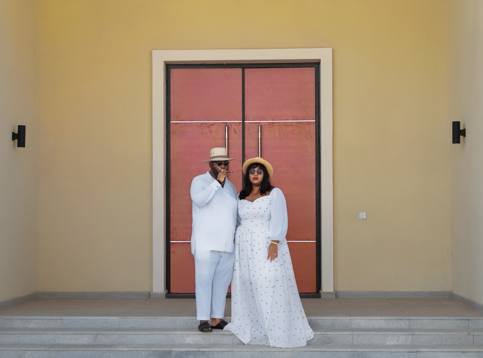 Couple posing in front of a colourful doorway on a sunny day