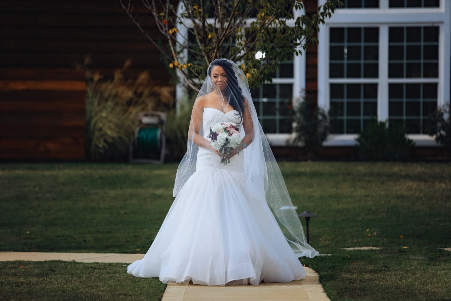 Bride standing outdoors in her gown and veil