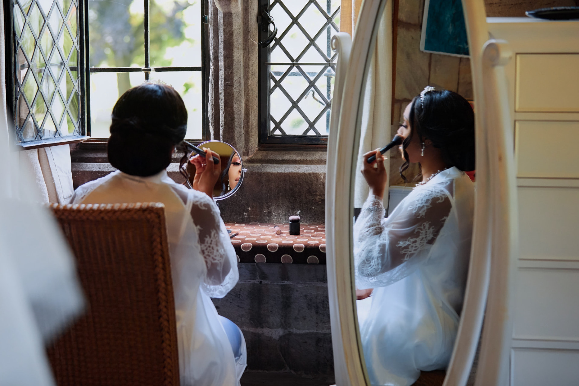Bride applying makeup at a mirror before the ceremony